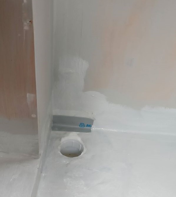 corner of tanked shower unit with hole for waste